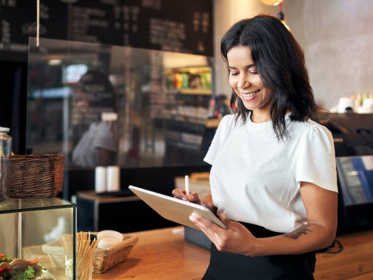 Happy manager using digital tablet for forms
